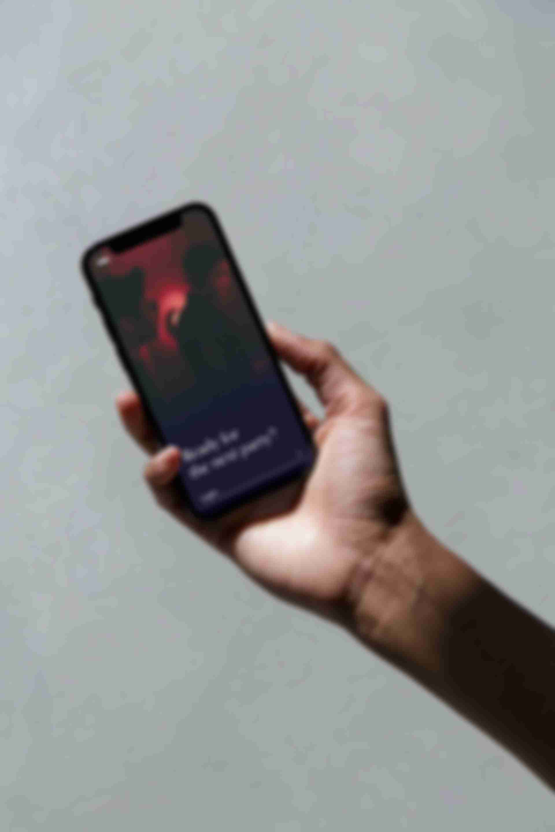 iPhone in a hand with the login screen for Echo Room on it.