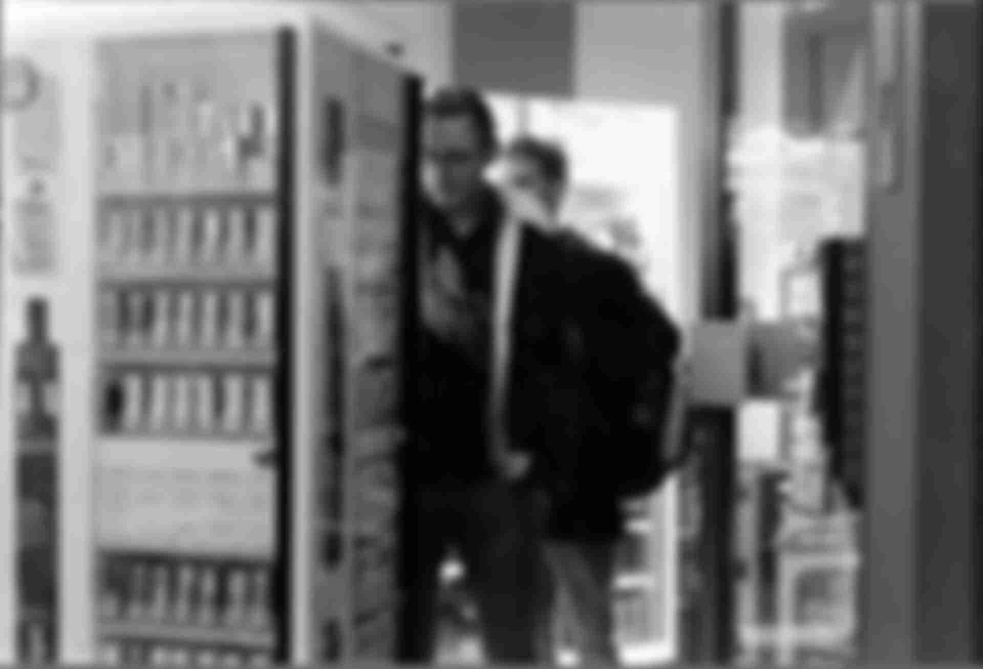 Two guys grabbing beer in a kiosk.