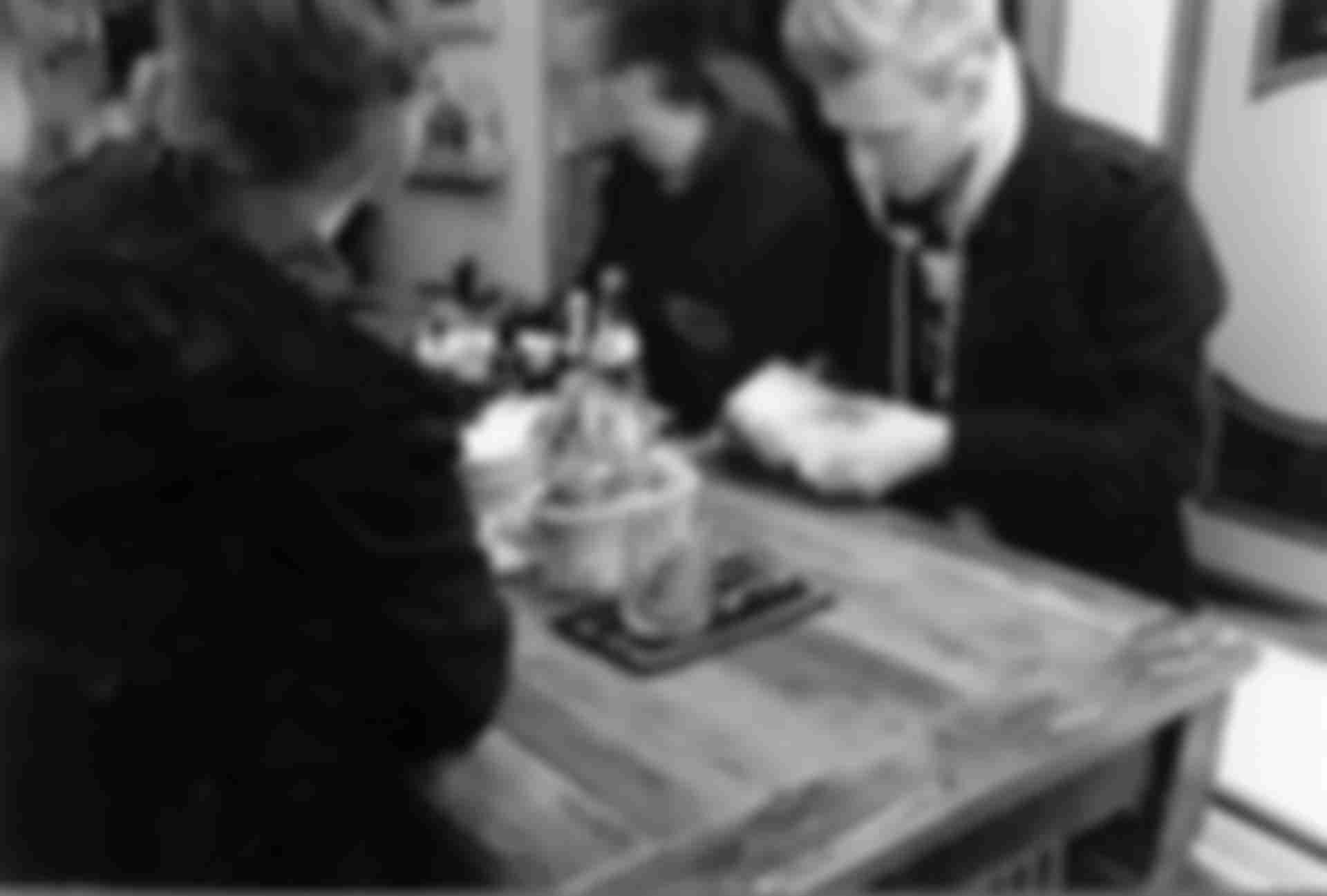 Three guys playing cards in a kiosk.