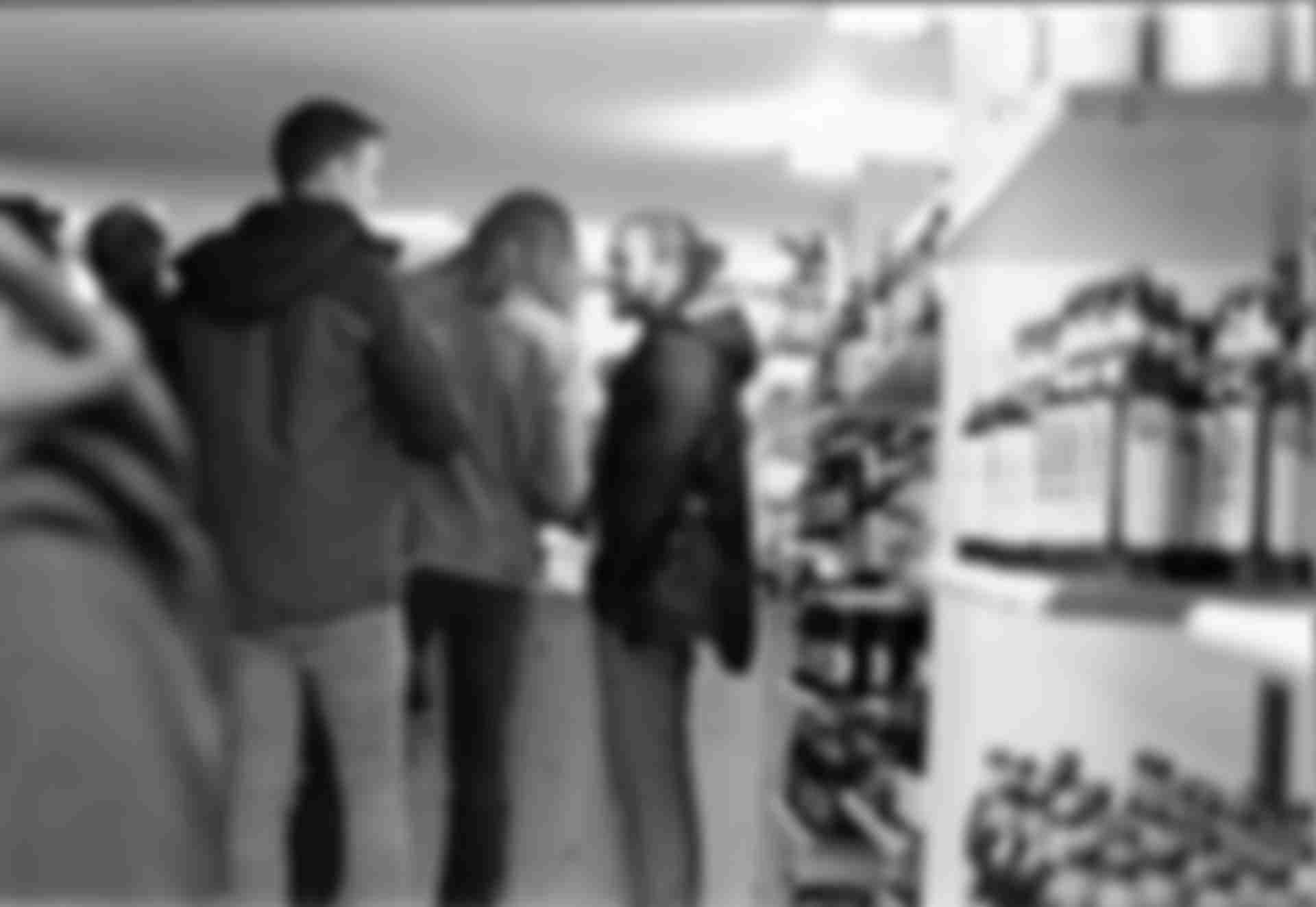 A group of people standing at a counter in a kiosk.