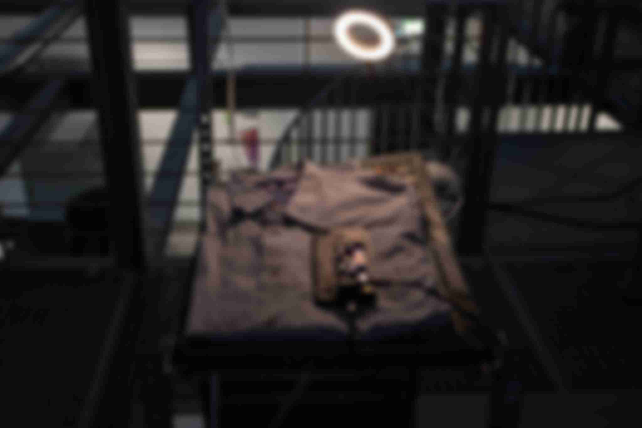 A folded shirt laying on a flat surface as part of the /sys/net/visible installation. A smartphone, powered by a Buck converter, is placed on top of the shirt.