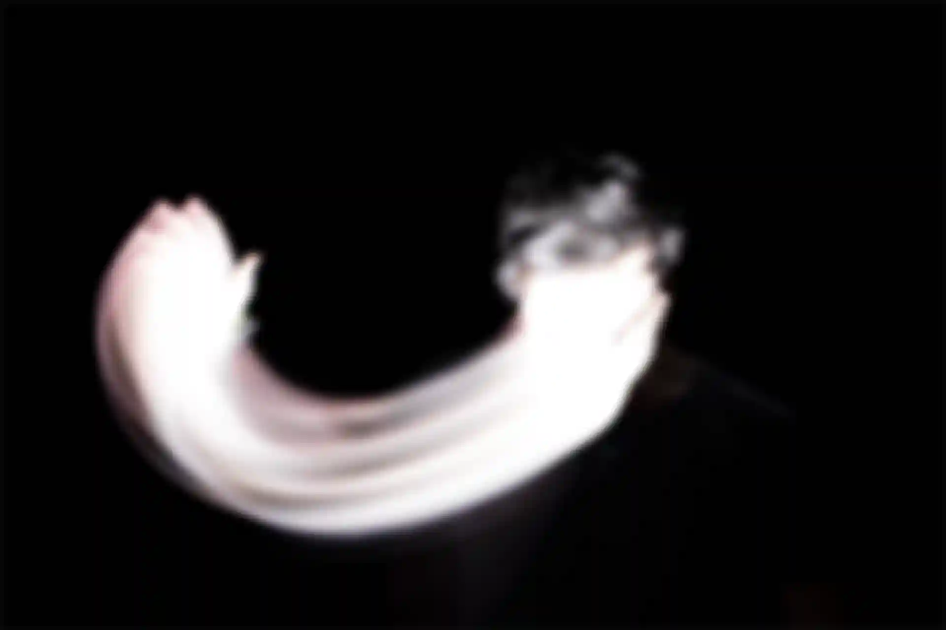 Ein Mann mit überbelichtetem Gesicht, der sein Gesicht mit einer Hand bedeckt.