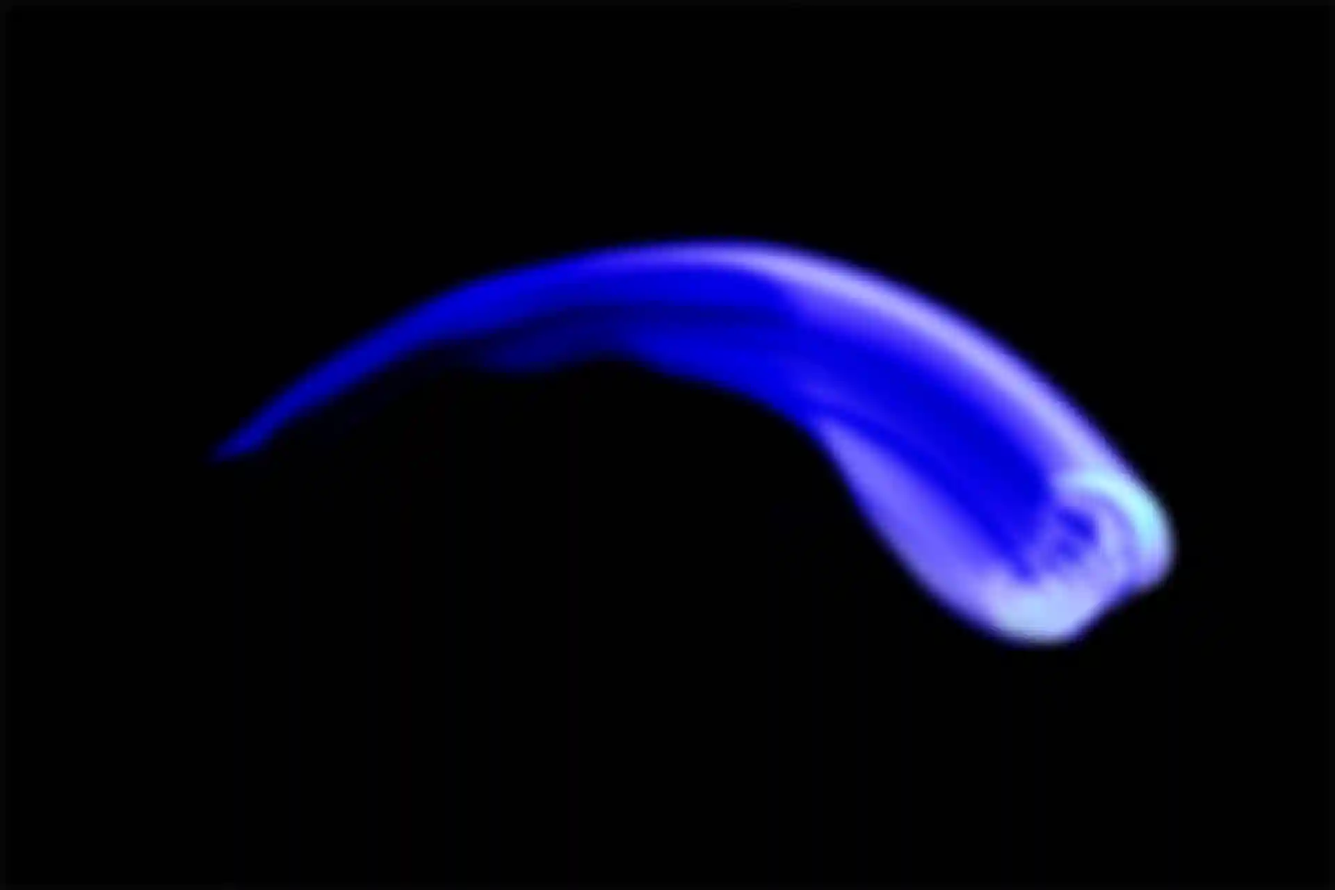 Ein Mann mit einem überbelichteten Gesicht bewegt seinen Kopf in einer Kurve von rechts nach links. Eine blaue Lichtquelle.